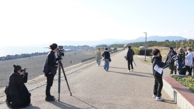 （写真）公園の海沿いを歩く加藤ローサさんと撮影スタッフ