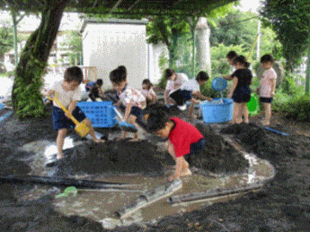砂場で水を使い川を作って遊んでいる写真