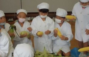 とうもろこしの皮をむく子どもたち