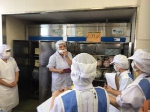 食器消毒保管庫の前で説明を受ける様子