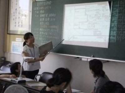黒板の図で説明をする講師