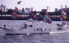 （写真）みなと祭りで大漁旗をはためかせて出港する漁船
