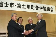 （写真）富士市・富士川町合併協議会が終了し、握手をする富士市・富士川町の関係者