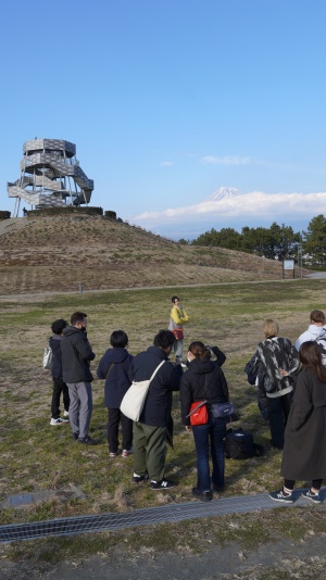 （写真）ドラゴンタワーをバックにポーズをとる様子