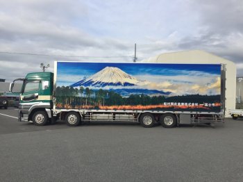 （写真）森林の奥にそびえ立つ明け方の富士山