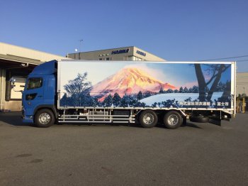 （写真）大型トラックの側面にプリントされた、朝日に照らされた富士山